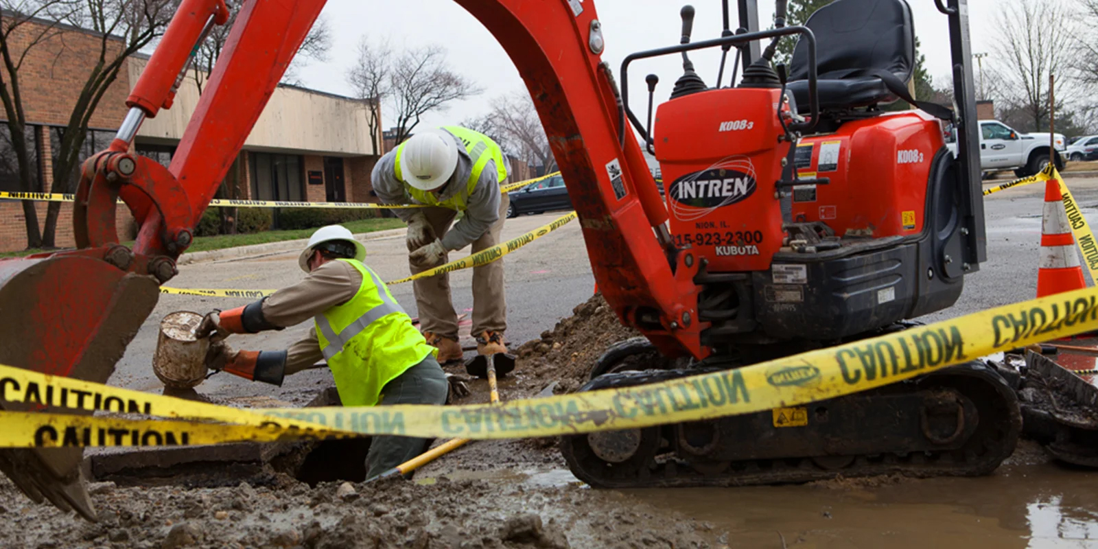 INTREN employees remove excess water and debris from trench to improve visibility of the work space.